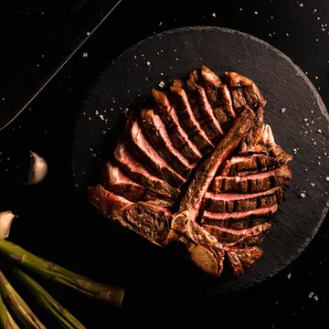 The Porterhouse steak is a premium cut that combines the best of two worlds: the tender Filet Mignon and the flavorful New York Strip, separated by a T-shaped bone.